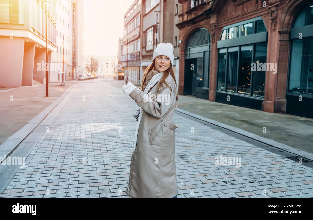 jeune femme souriante ayant un moment amusant, en utilisant des téléphones à l'extérieur dans une ville urbaine. Personnes, communication, shopping et concepts de style de vie Banque D'Images