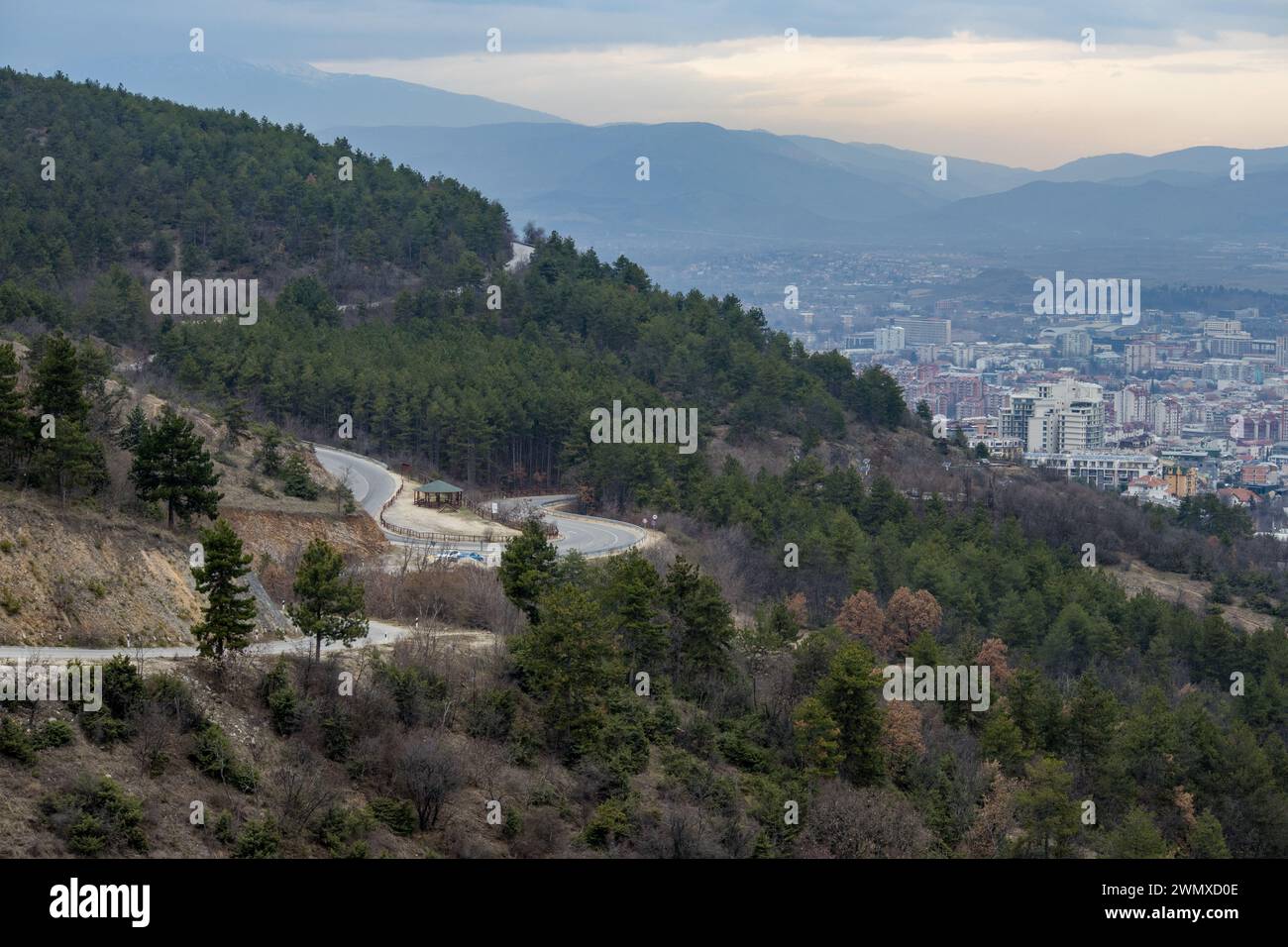 Ville de montagne européenne vue d'en haut au coucher du soleil sur un jour nuageux, Skopje la capitale. Banque D'Images