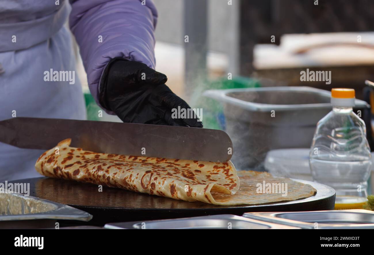 Le corps de la section médiane d'un chef préparant des crêpes, des crêpes françaises sur le stand du marché fermier à Prague Naplavka, République tchèque Banque D'Images