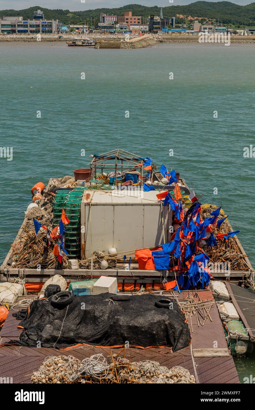 Barge chargée de fournitures de pêche industrielle dans l'eau au port de Hongwon en Corée du Sud Banque D'Images