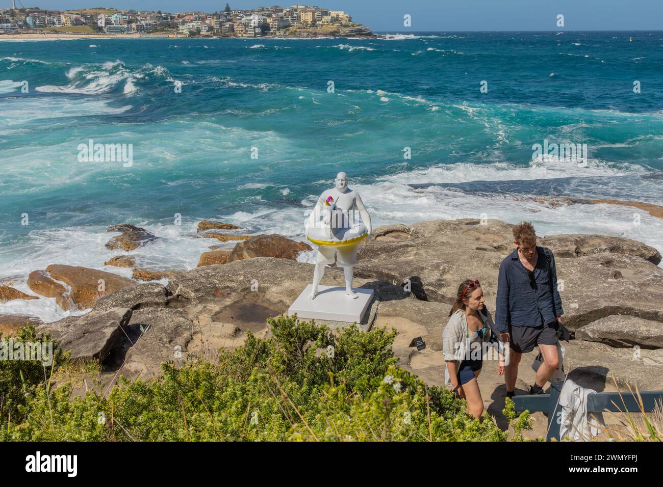 Les visiteurs se promènent devant « David » by Coady, qui fait partie de l'exposition « sculpture by the Sea » sur la promenade côtière entre les plages de Bondi et Tamarama. Banque D'Images