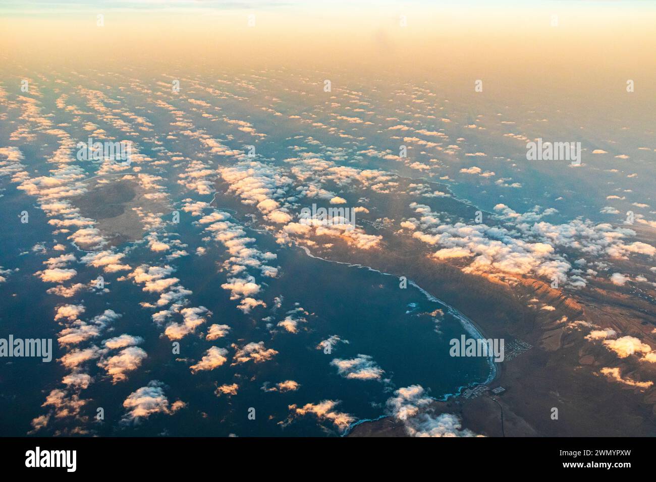 Caleta de Famara et la Bahia de Penedo sur l'île Canaries de Lanzarote, Espagne vue d'un avion de passage vers le coucher du soleil. Banque D'Images