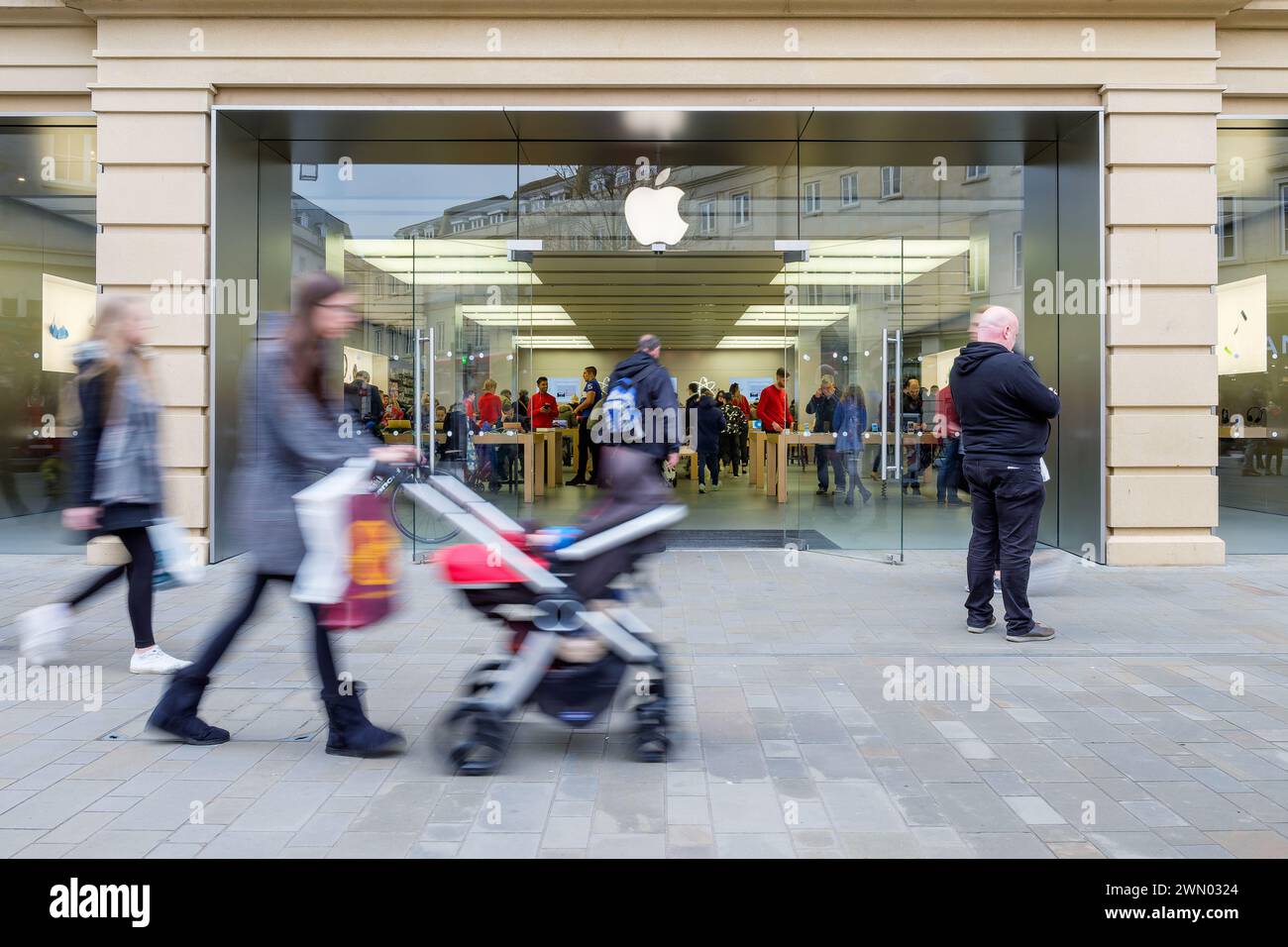 Les acheteurs sont photographiés marchant devant un magasin de pommes / magasin à Bath England Royaume-Uni. Bain 17 décembre 2016 Banque D'Images