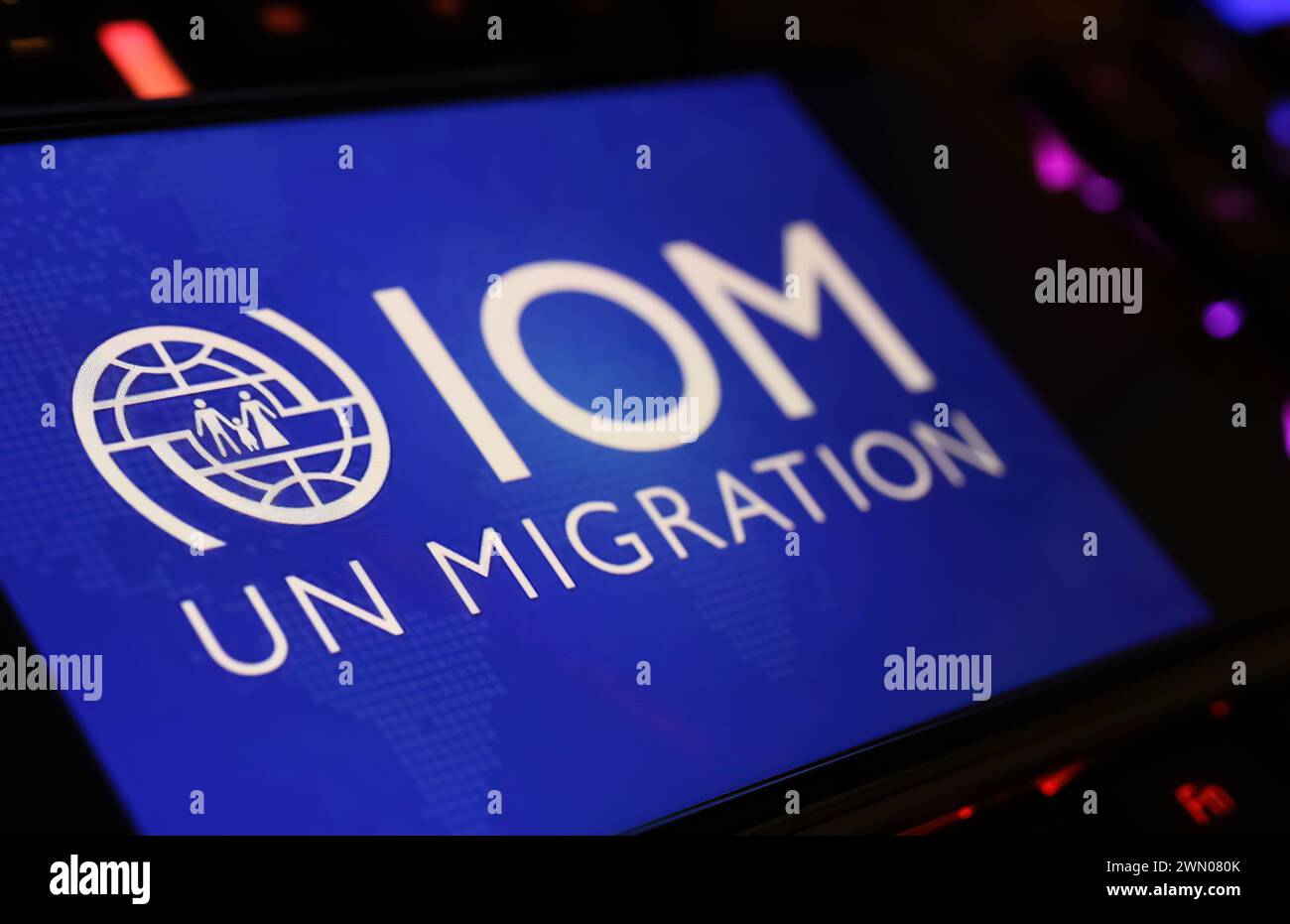 Viersen, Allemagne - 9 janvier. 2024 : écran de smartphone avec lettrage de logo de l'agence des Nations Unies Organisation internationale pour les migrations OIM sur keybo d'ordinateur Banque D'Images