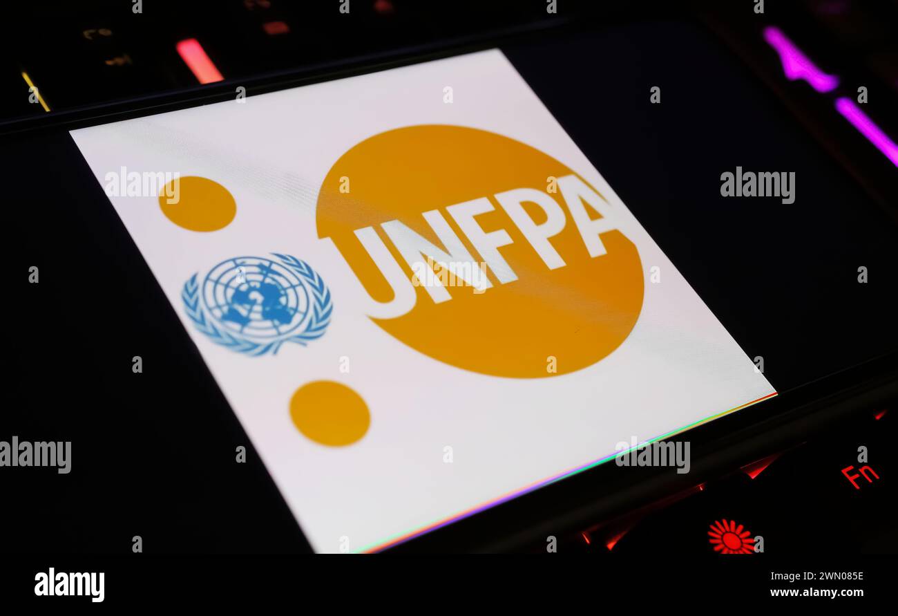 Viersen, Allemagne - 9 janvier. 2024 : écran de smartphone avec lettrage logo de l'agence des Nations Unies UNFPA sur clavier d'ordinateur Banque D'Images