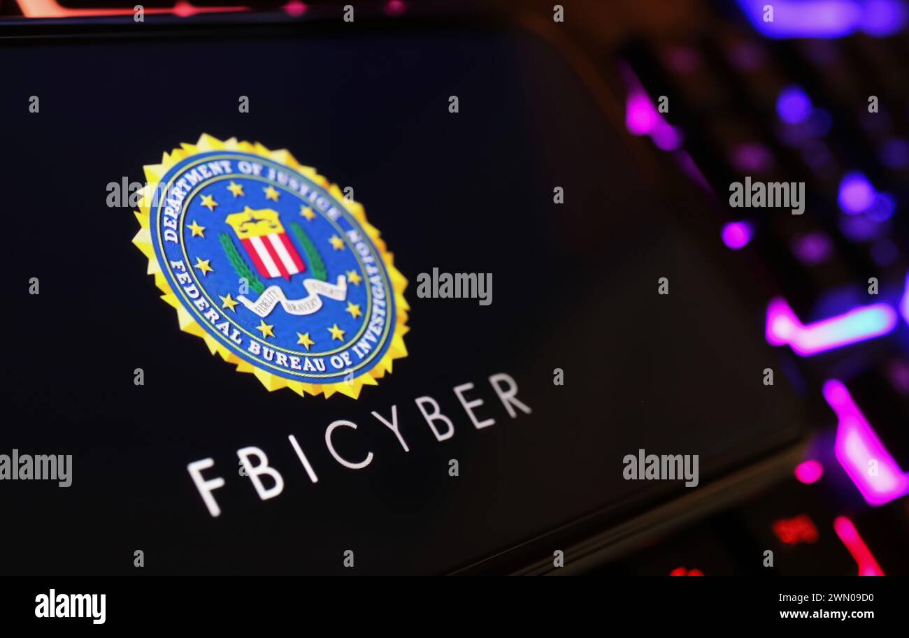 Viersen, Allemagne - 9 janvier. 2024 : écran de smartphone avec lettrage logo de FBI Cyber sur le clavier de l'ordinateur Banque D'Images