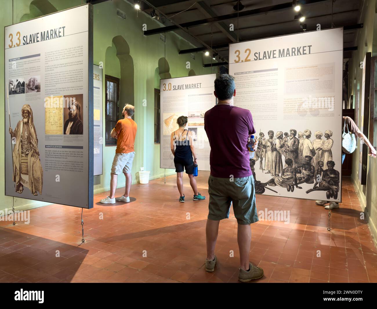 Les touristes occidentaux regardent les expositions dans l'East Africa Slave Trade Exhibition, Stone Town, Zanzibar, Tanzanie Banque D'Images