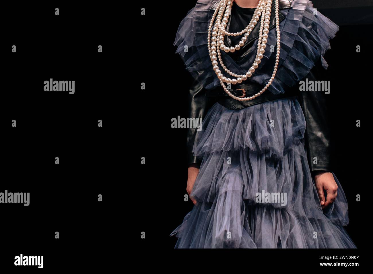 Robe en satin bleu avec volants et perles de perles sur fond noir. Look élégant et tendance Banque D'Images