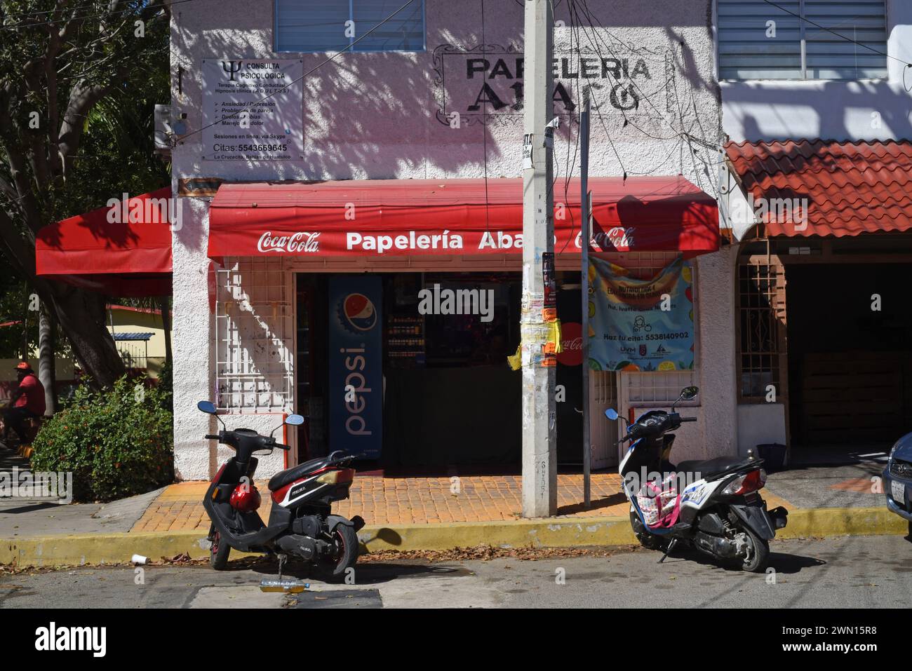Motos scooter garées devant un magasin de papeterie à Huatulco, Oaxaca, Mexique Banque D'Images
