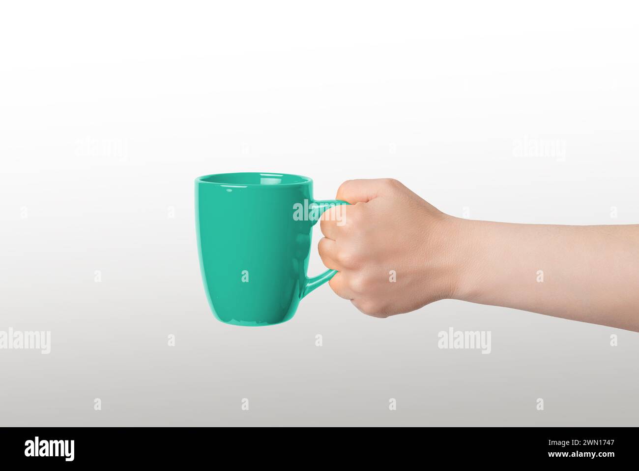 Tasse verte tenue pour promouvoir le logo ou illustrer le café et le thé sirotant Banque D'Images