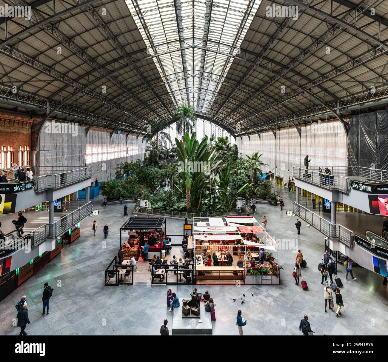 MADRID, ESPAGNE - 23 MARS 2023 : voyageurs dans le jardin tropical de la gare d'Atocha, Madrid, Espagne. Banque D'Images