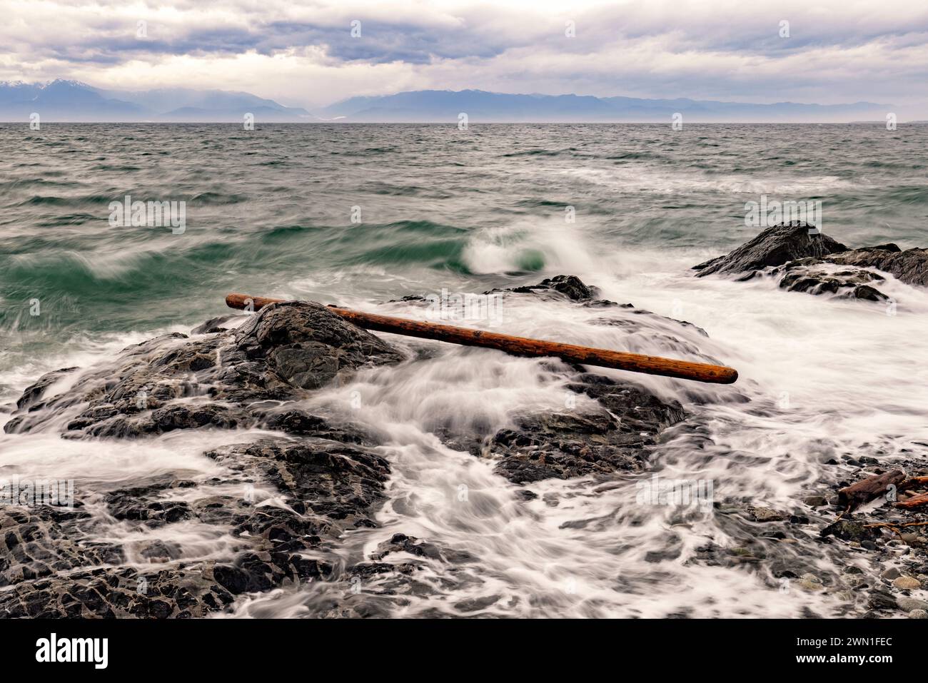 Longue exposition de surf et de bois flotté le long de la rive rocheuse - Victoria, île de Vancouver, Colombie-Britannique, Canada Banque D'Images