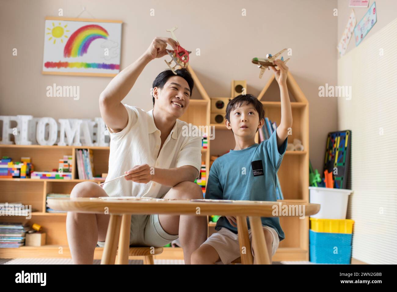 Jeune père un fils fabriquant un avion en bois Banque D'Images