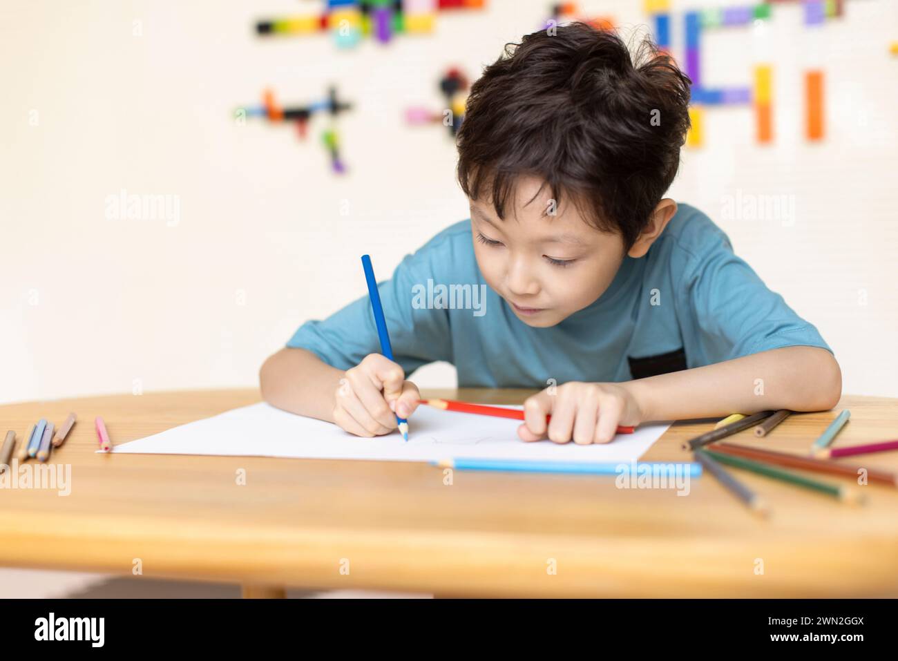 Cute boy drawing in classroom Banque D'Images
