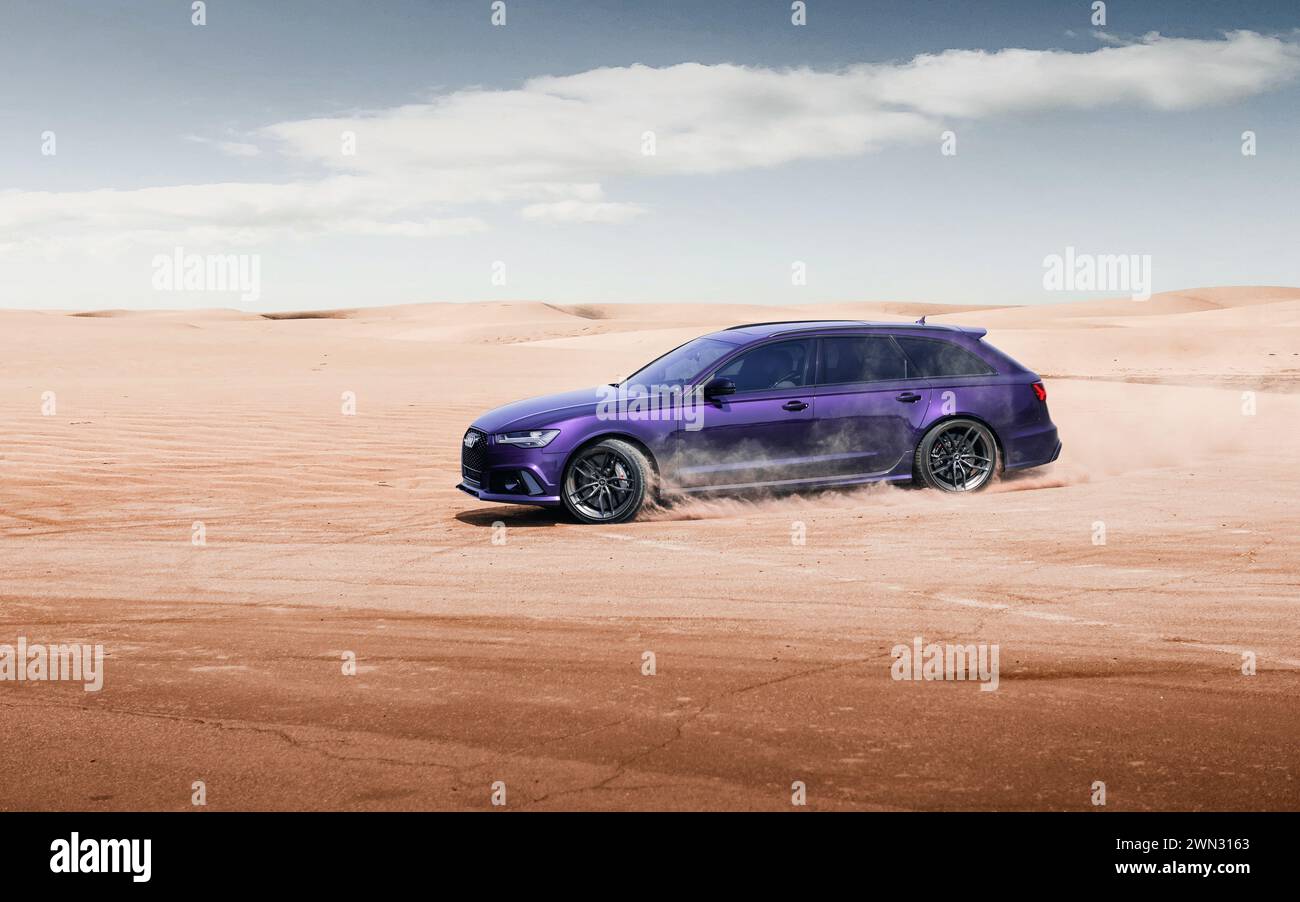 Merlin Purple Audi RS6 powerslide dans une zone déserte. Vue de trois quarts avant de la version performance de l'Audi A6 avant (génération C6) conduisant sur la poussière. Banque D'Images