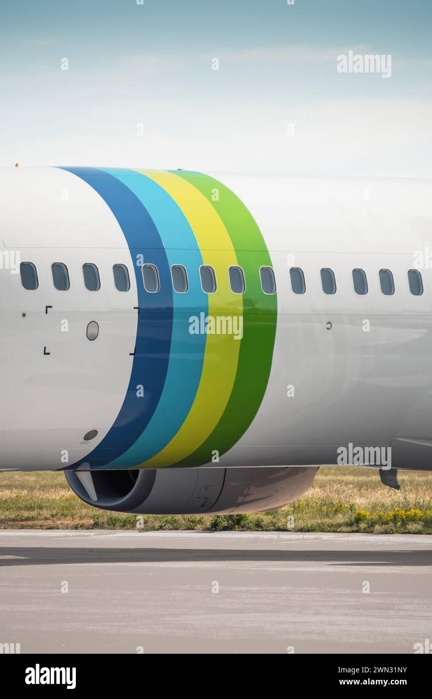 Fuselage d'avion de passagers. Image verticale de la section de fuselage avec des anneaux colorés. Vue rapprochée d'un avion stationné sur l'aire de trafic. Banque D'Images