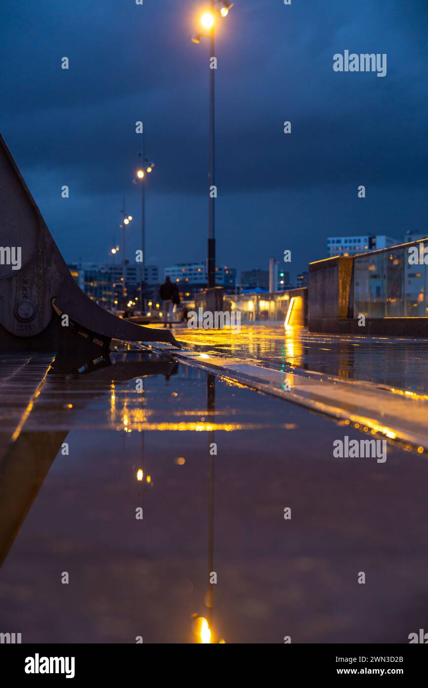 Rue humide dans la gare centrale d'Amsterdam avec réflexion de l'eau sur la rue Banque D'Images