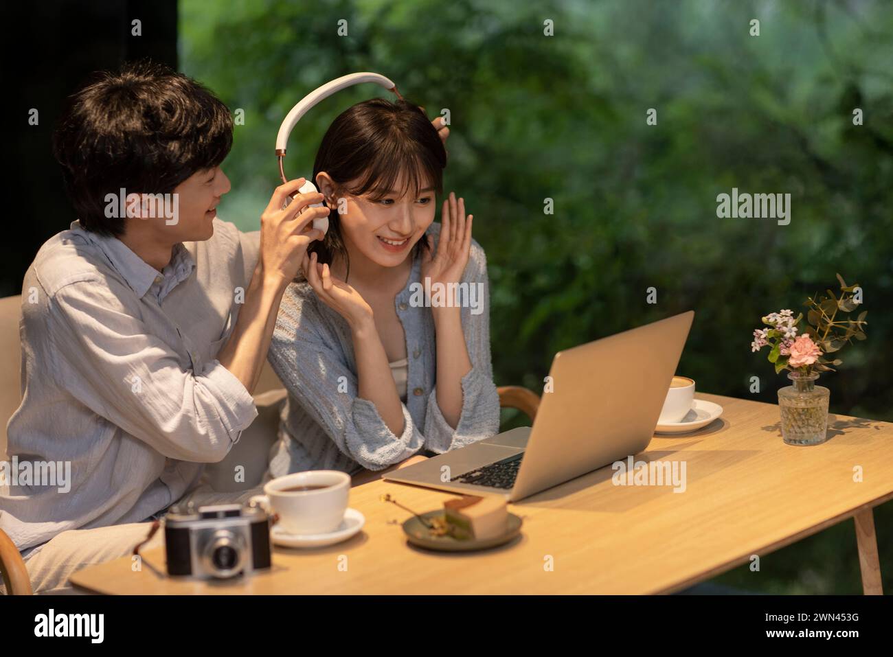Jeune couple utilisant un ordinateur portable dans le café Banque D'Images