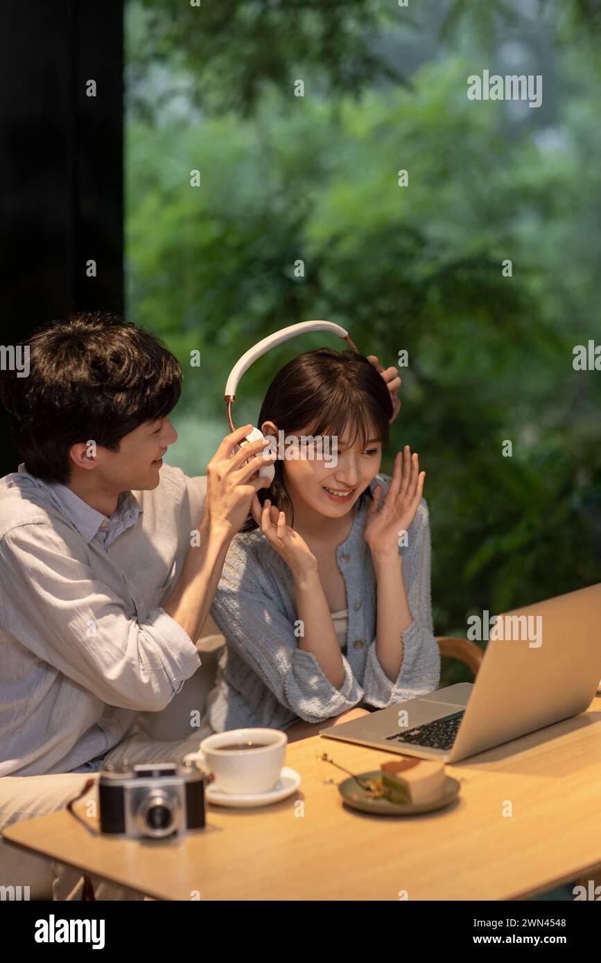 Jeune couple utilisant un ordinateur portable dans le café Banque D'Images