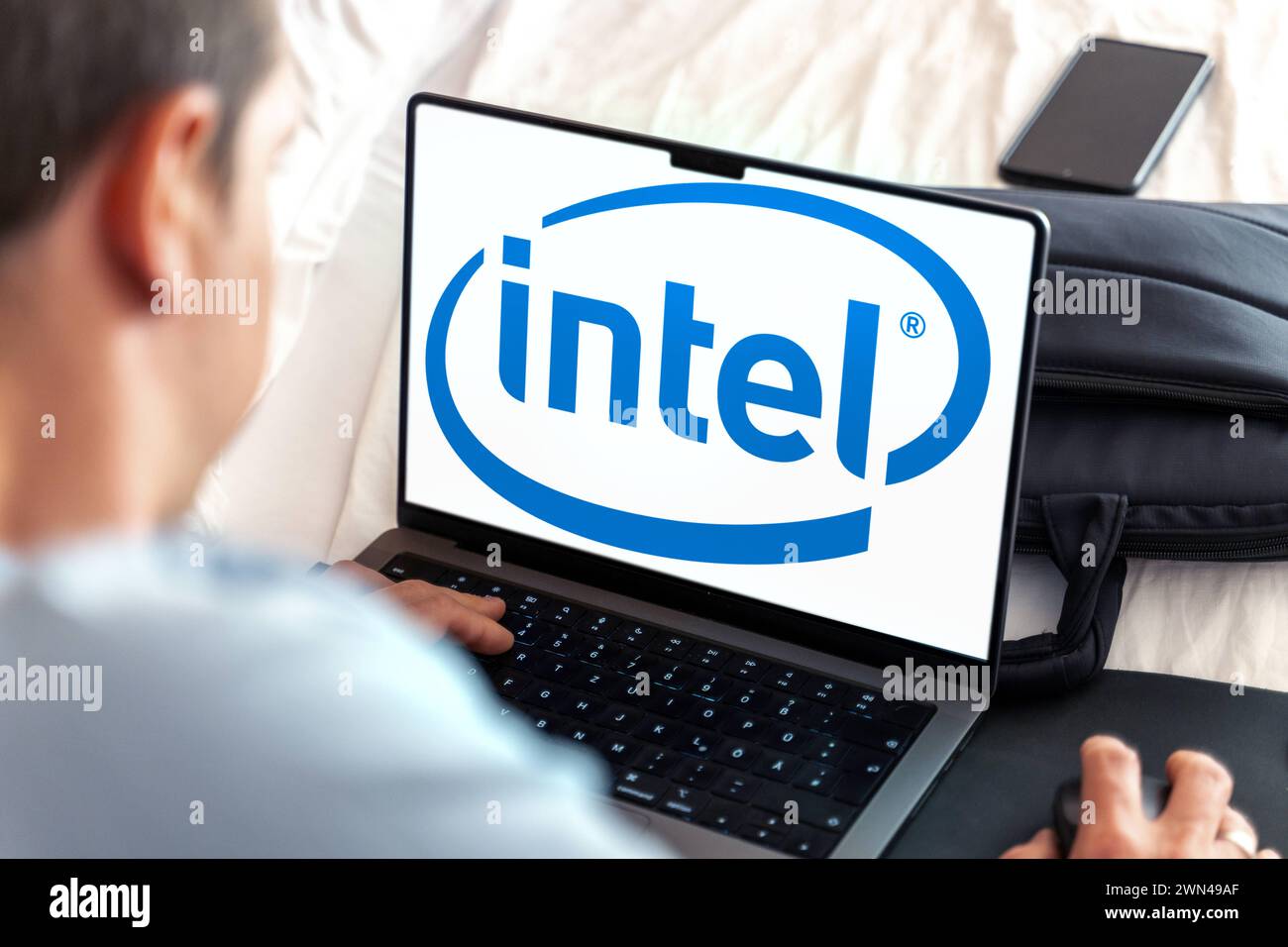 29 février 2024 : homme assis à son ordinateur portable, le logo Intel sur l'écran. PHOTOMONTAGE *** Mann sitzt am Laptop, im Bildschirm das logo von Intel. FOTOMONTAGE Banque D'Images