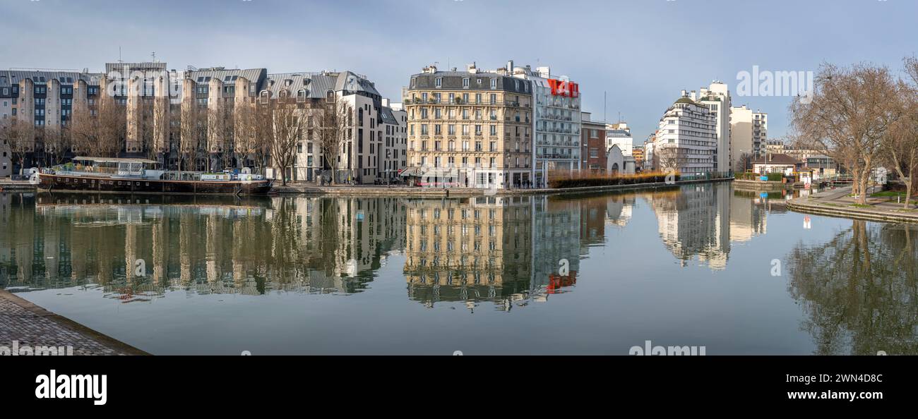 Paris, France - 01 27 2024 : canal de l'Ourcq. Réflexions sur le canal Ourcq des bâtiments résidentiels, pont, péniches et la rotonde de Stalingrad Banque D'Images