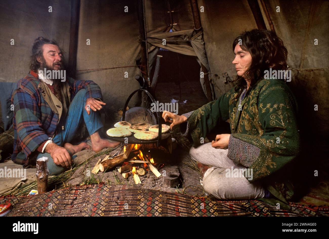 Communauté Hippy 1980s Royaume-Uni. Groupe gallois respectueux de l'environnement de TIPI Valley de hippies New age. Couple hippie John Silvani et Crazy Crow Yvonne Maya vivant hors réseau vu dans leur Tepee cuisiner sur feu ouvert. Llandeilo, pays de Galles 1985 HOMER SYKES Banque D'Images