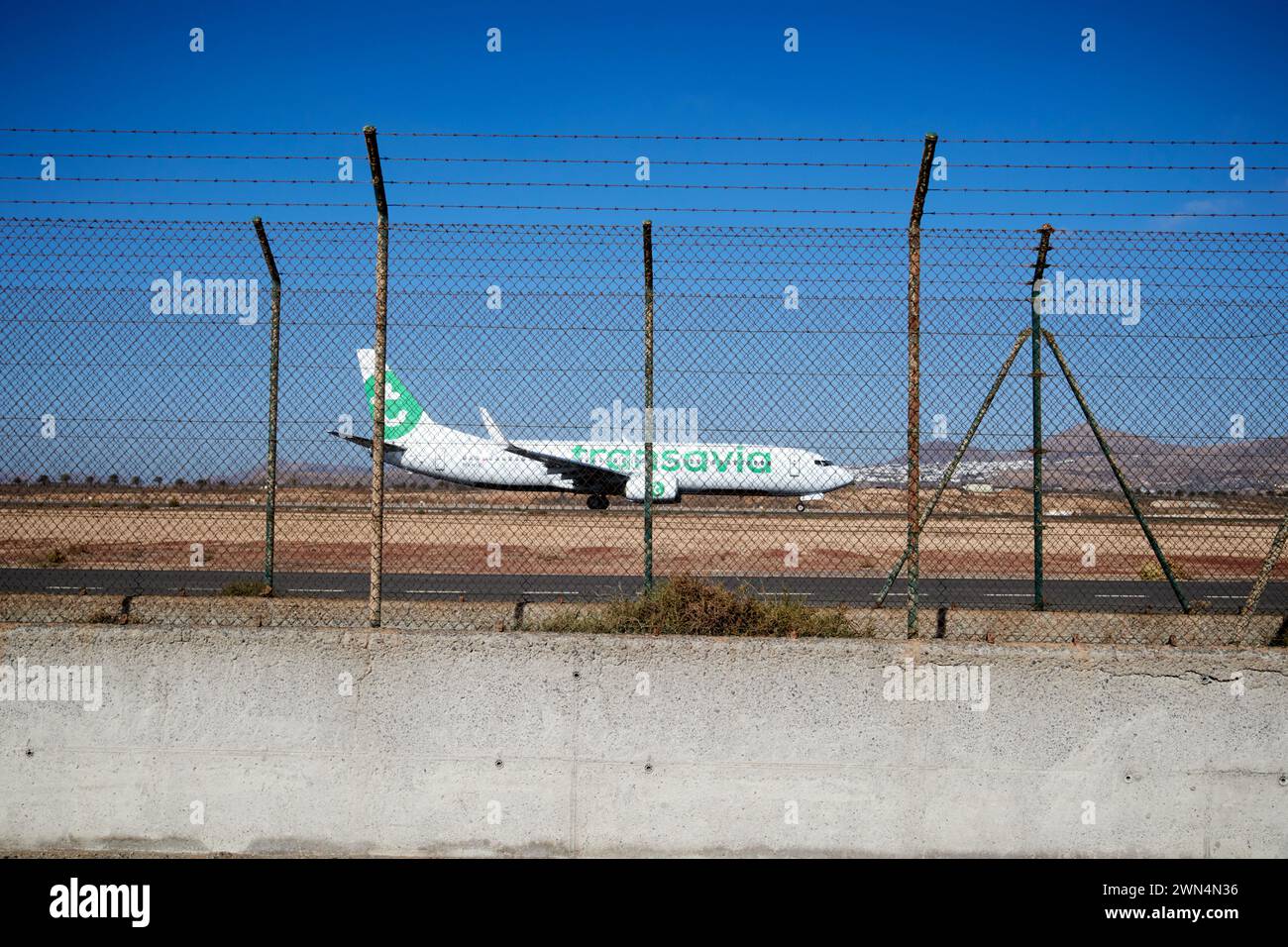 Clôture de sécurité de maillon de chaîne de fil de fer barbelé comme transavia Aircraft débarque Lanzarote, îles Canaries, espagne Banque D'Images