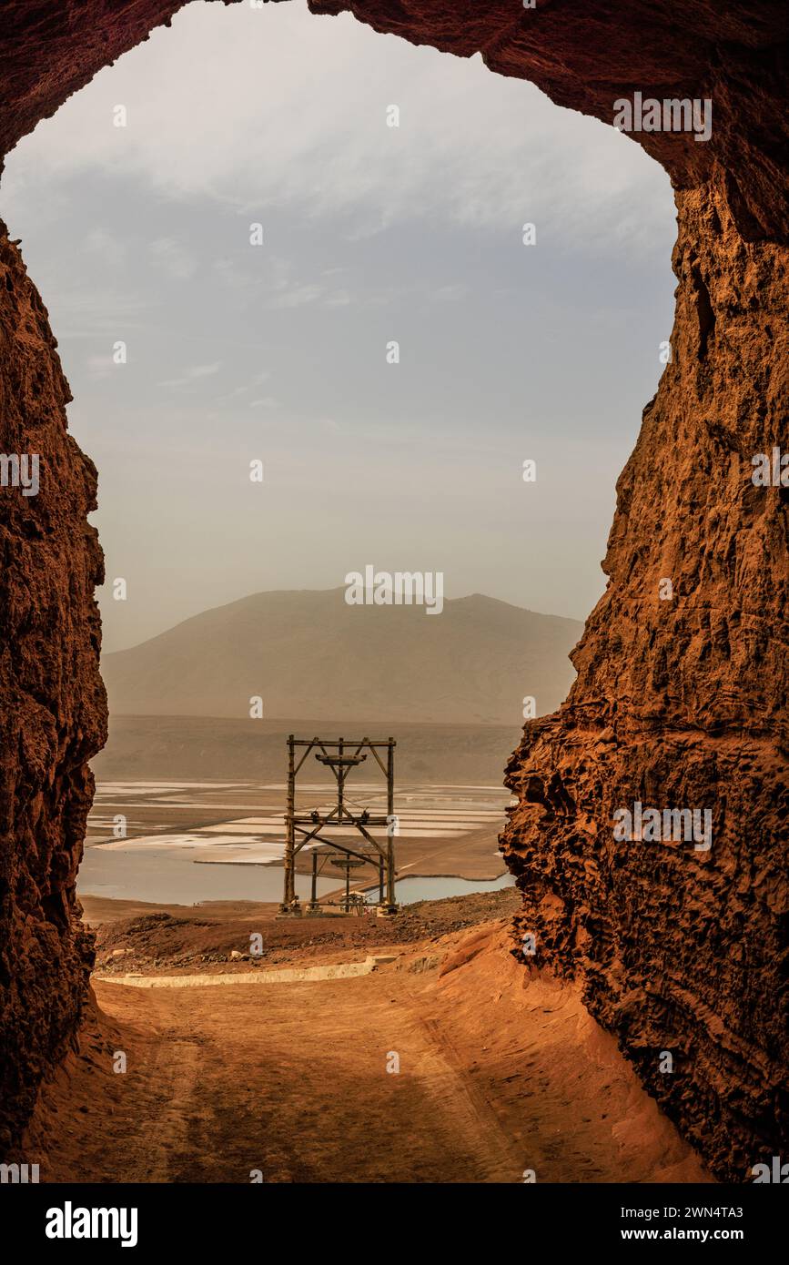 le lac salé rose de pedra de lune dans le cratère volcanique et les cadres en bois du téléphérique vu à travers l'arche du tunnel mural du cratère Banque D'Images