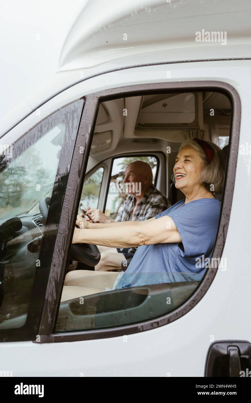 Femme âgée heureuse conduisant le camping-car avec l'homme pendant le voyage sur la route Banque D'Images