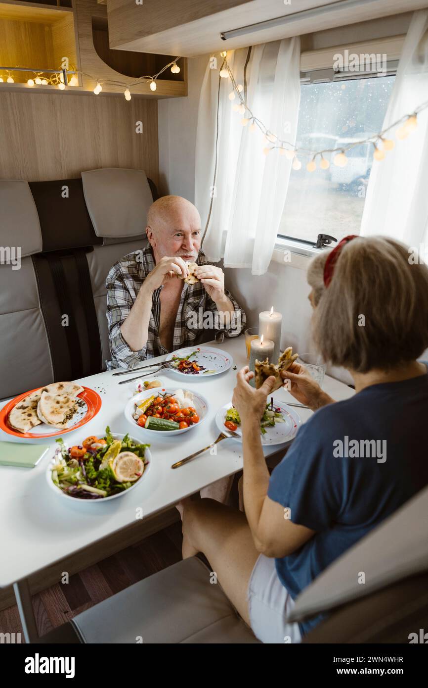 Couple de personnes âgées à la retraite mangeant le déjeuner ensemble dans un camping-car Banque D'Images