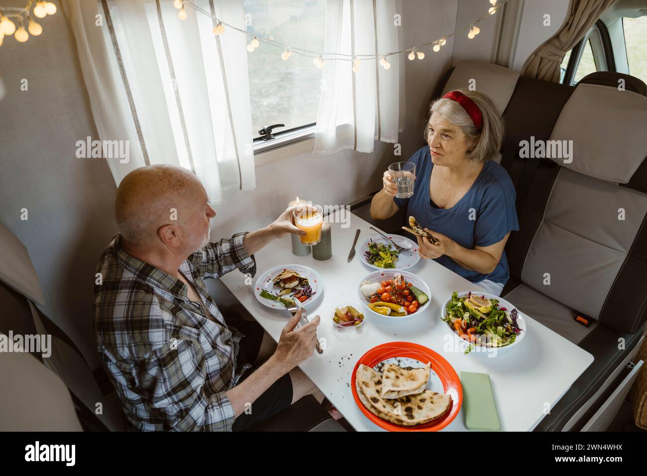Couple senior mangeant le déjeuner tout en discutant ensemble dans le camping-car Banque D'Images