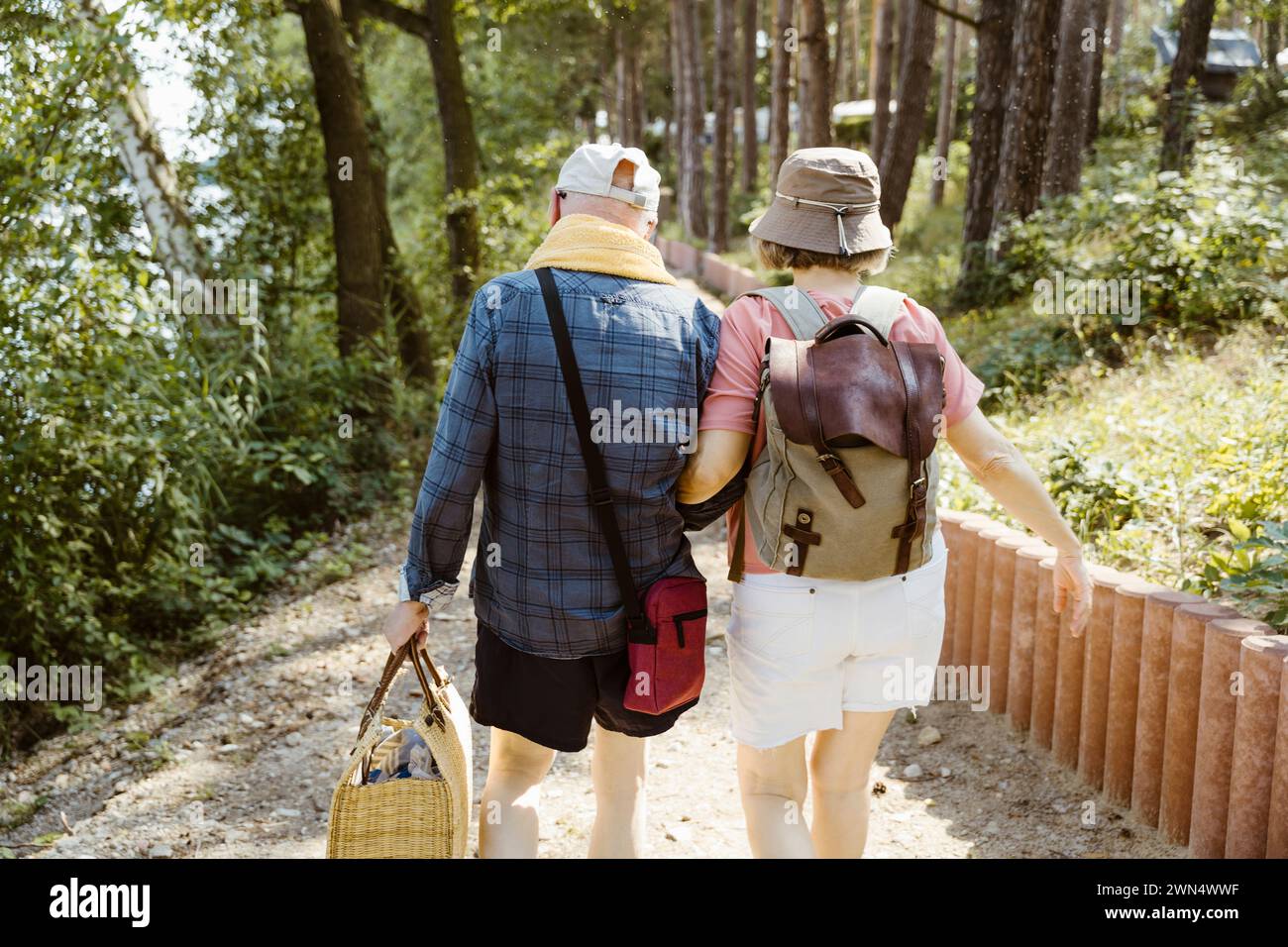 Vue arrière d'un couple de personnes âgées retraitées marchant ensemble lors d'une randonnée en forêt Banque D'Images