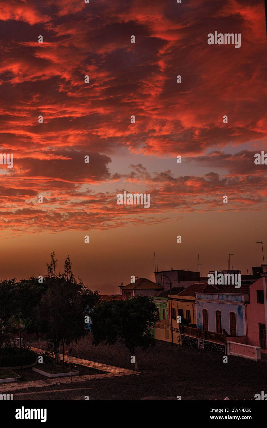 le soleil se couche derrière la silhouette d'ilha brava éclairant sous les lourds nuages bas un rouge brillant avec l'île de fogo au premier plan au cap vert Banque D'Images