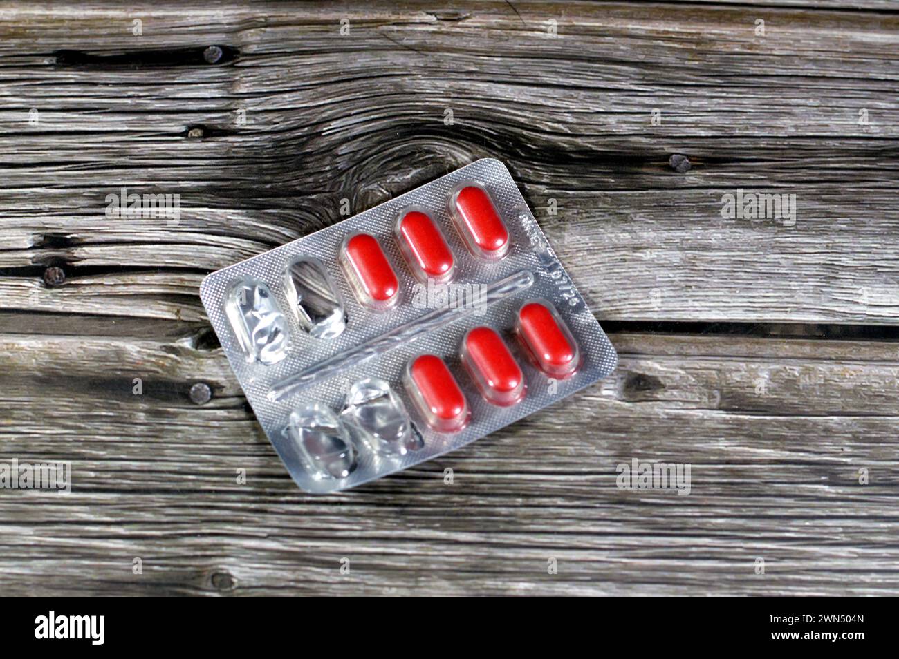 Comprimés de médicaments, comprimés rouges, traitement, remède, consommation de drogues, abus, concept de prescription, analgésiques et antibiotiques, analgésiques, prise d'un médicament Banque D'Images