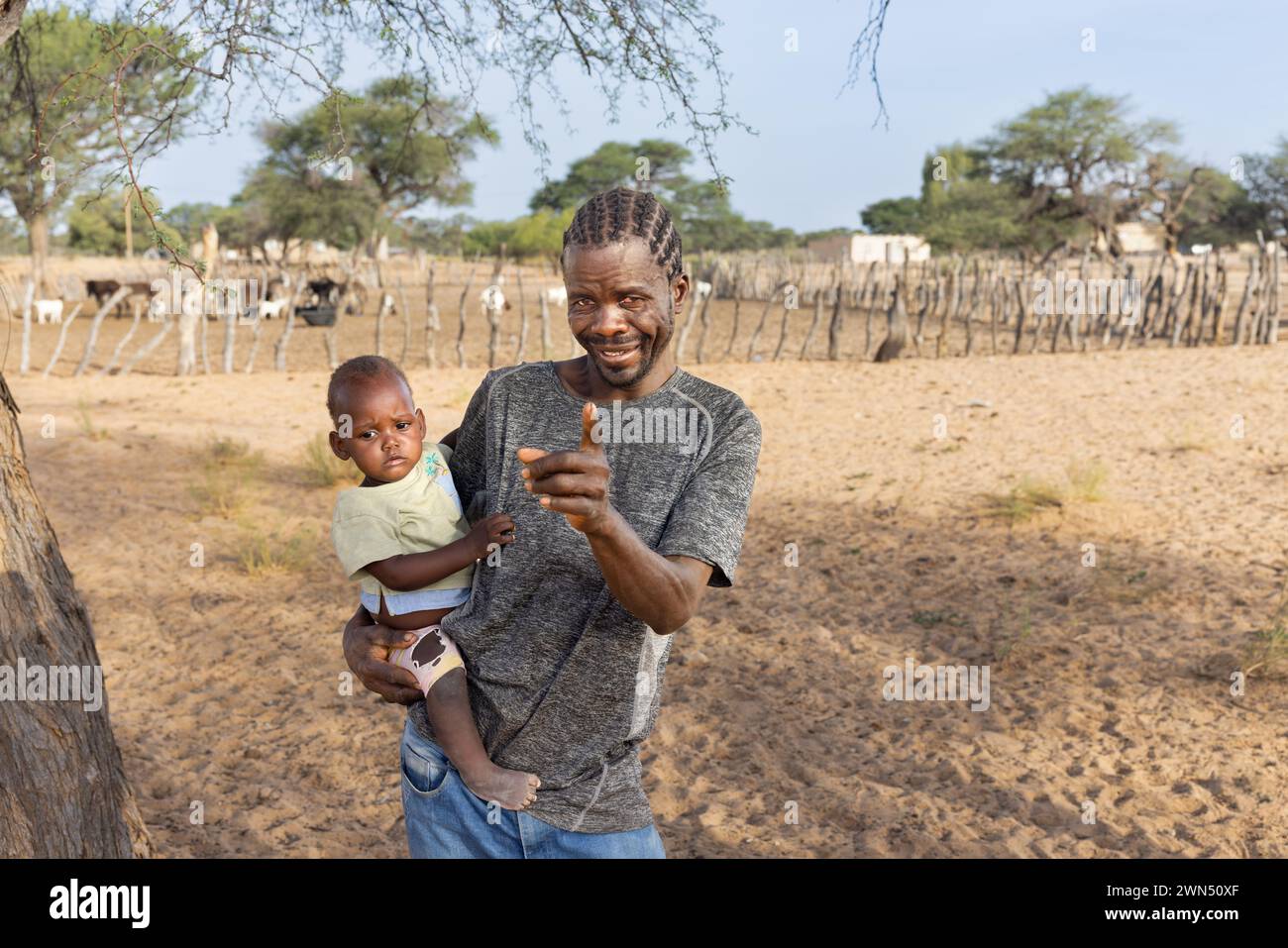 homme de village africain avec des tresses tenant dans ses bras et jouant avec sa fille Banque D'Images