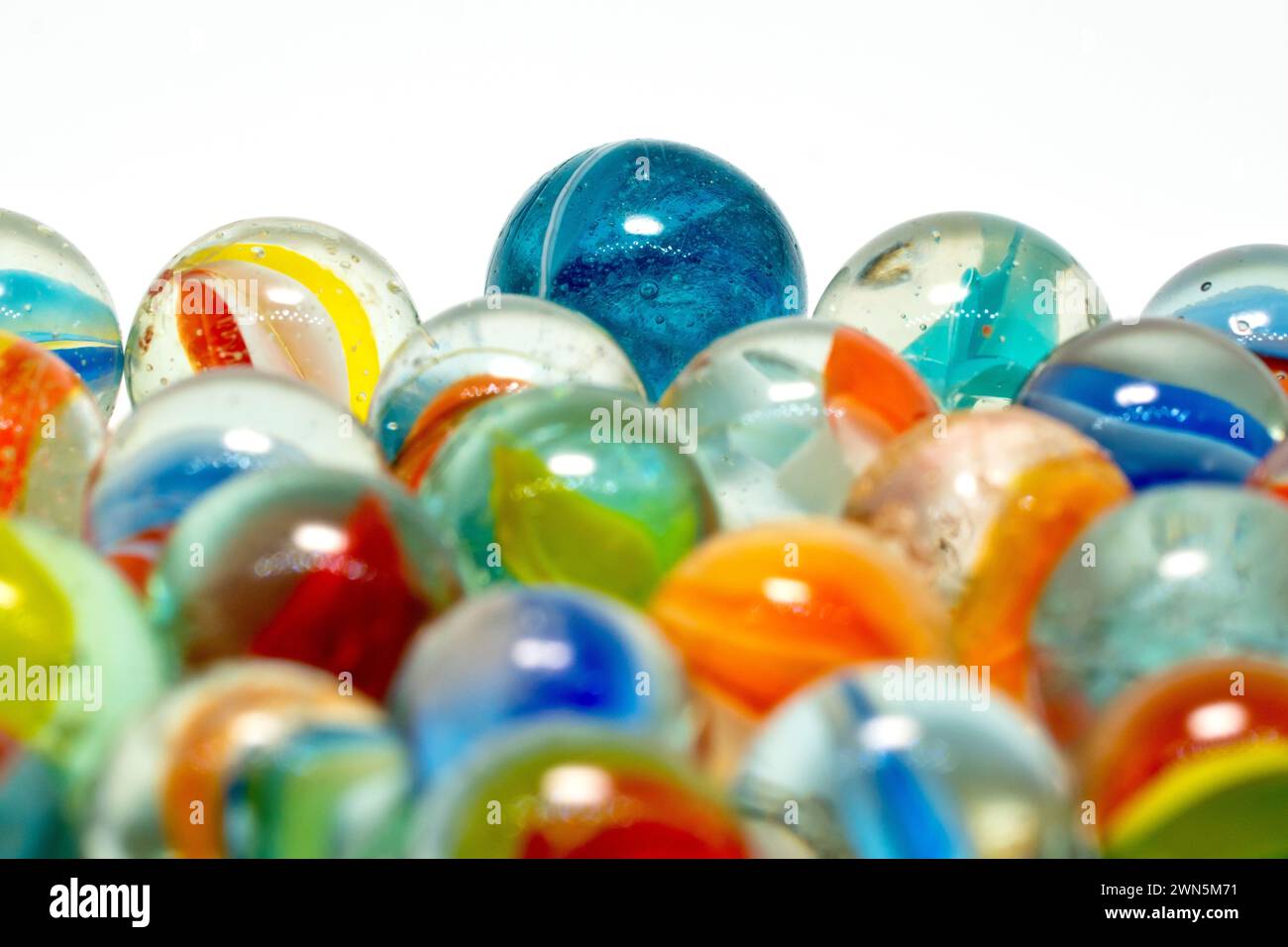 Gros plan de plusieurs marbres de verre colorés, un jouet ou un jeu populaire parmi les jeunes garçons, isolé sur un fond blanc. Banque D'Images