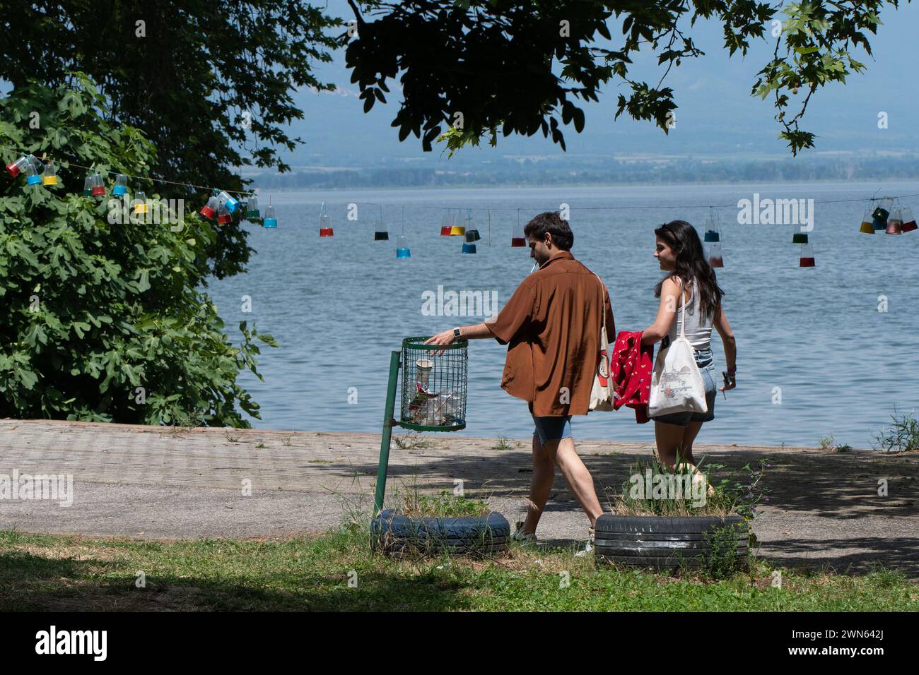 Les jeunes, se soucie de la nature. Jeter les déchets dans la poubelle verte. Concept d'écologie. Jeunesse soucieuse de l'environnement. Cultiver un avenir plus vert. Banque D'Images