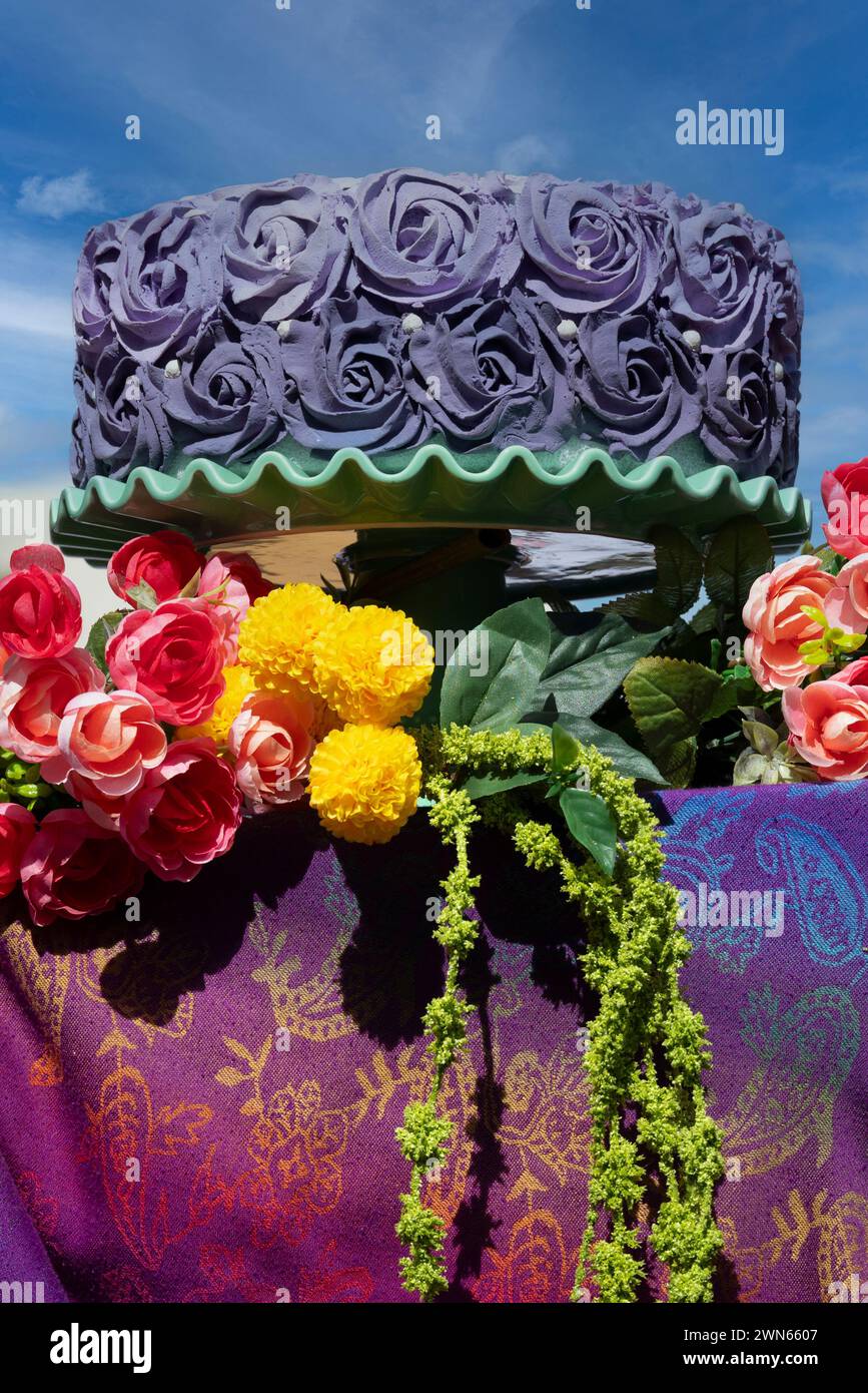 Une exposition extérieure d'un décoloration violet sur gâteau avec des motifs vibrants et colorés pour des friandises de confiserie au stand de la foire d'art. Banque D'Images