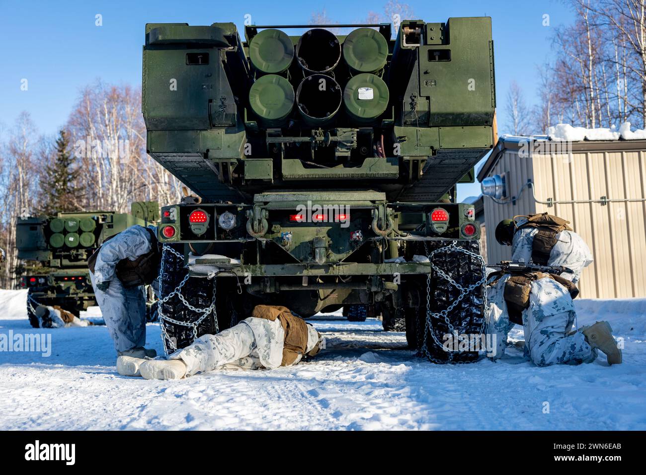Les Marines américains avec Fox Battery, 2e bataillon, 14e régiment de Marines, 4e division des Marines, réserve des Forces marines attachent des chaînes à neige aux pneus d'un véhicule HIMARS (High Mobility Artillery Rocket System) avant d'entreprendre une infiltration rapide HIMARS, également connue sous le nom de HIRAIN, au cours de l’exercice Arctic Edge 2024 à la base aérienne d’Eielson, Alaska, le 24 février 2024. Le système d'armes HIMARS est un élément crucial de l'élément de combat au sol de la Marine Air-Ground Task Force (MAGTF). Les HIMARS jouent un rôle central dans la fourniture de feux de précision à longue portée pour soutenir les objectifs de la MAGTF, depuis Expeditionary Banque D'Images