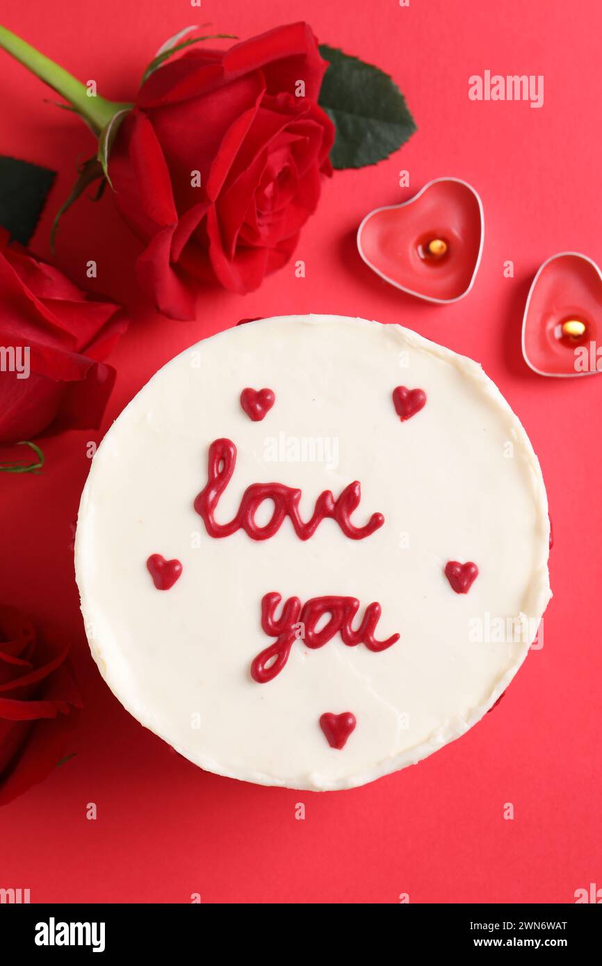 Bento gâteau avec texte Love You, roses et bougies sur la table rouge, plat. Prog Surprise pour la Saint-Valentin Banque D'Images