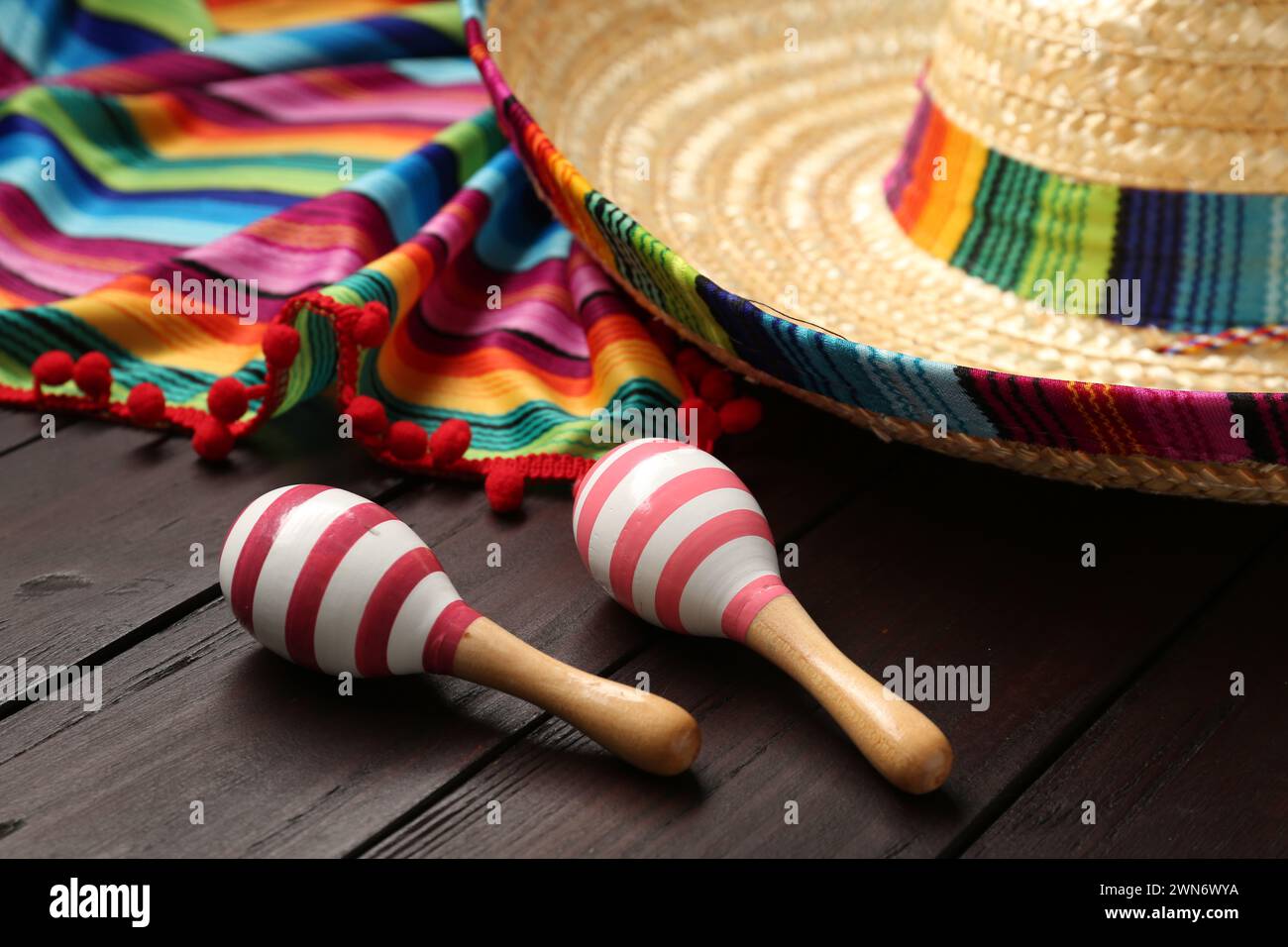 Chapeau sombrero mexicain, maracas et poncho coloré sur fond en bois Banque D'Images