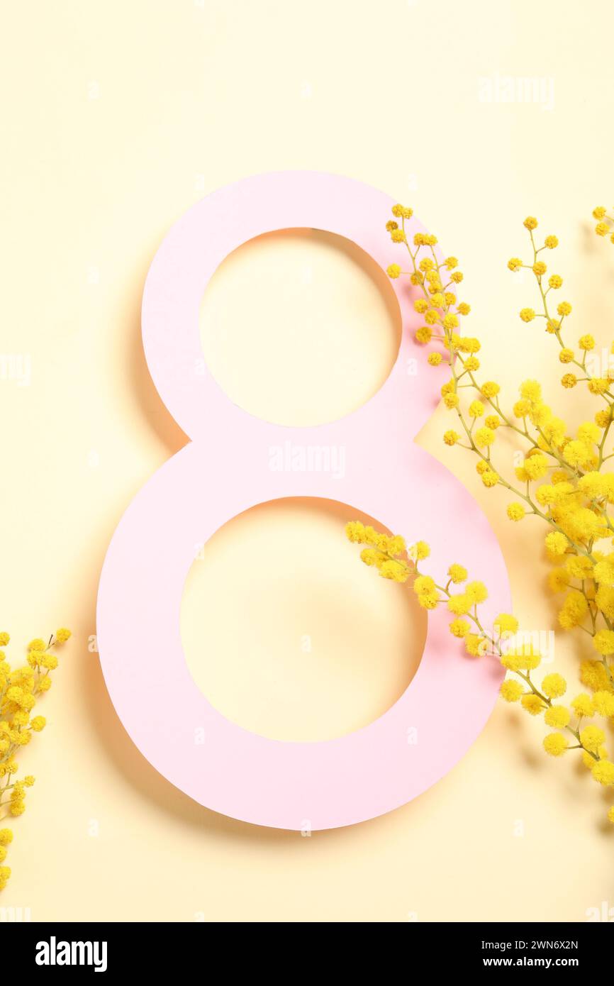 8 mars conception de carte de voeux avec des fleurs de mimosa sur fond jaune clair, vue de dessus Banque D'Images
