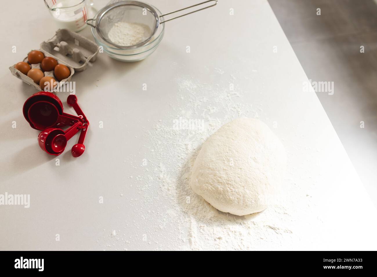 Scène de cuisson avec farine, pâte et ingrédients prêts sur le comptoir. Banque D'Images