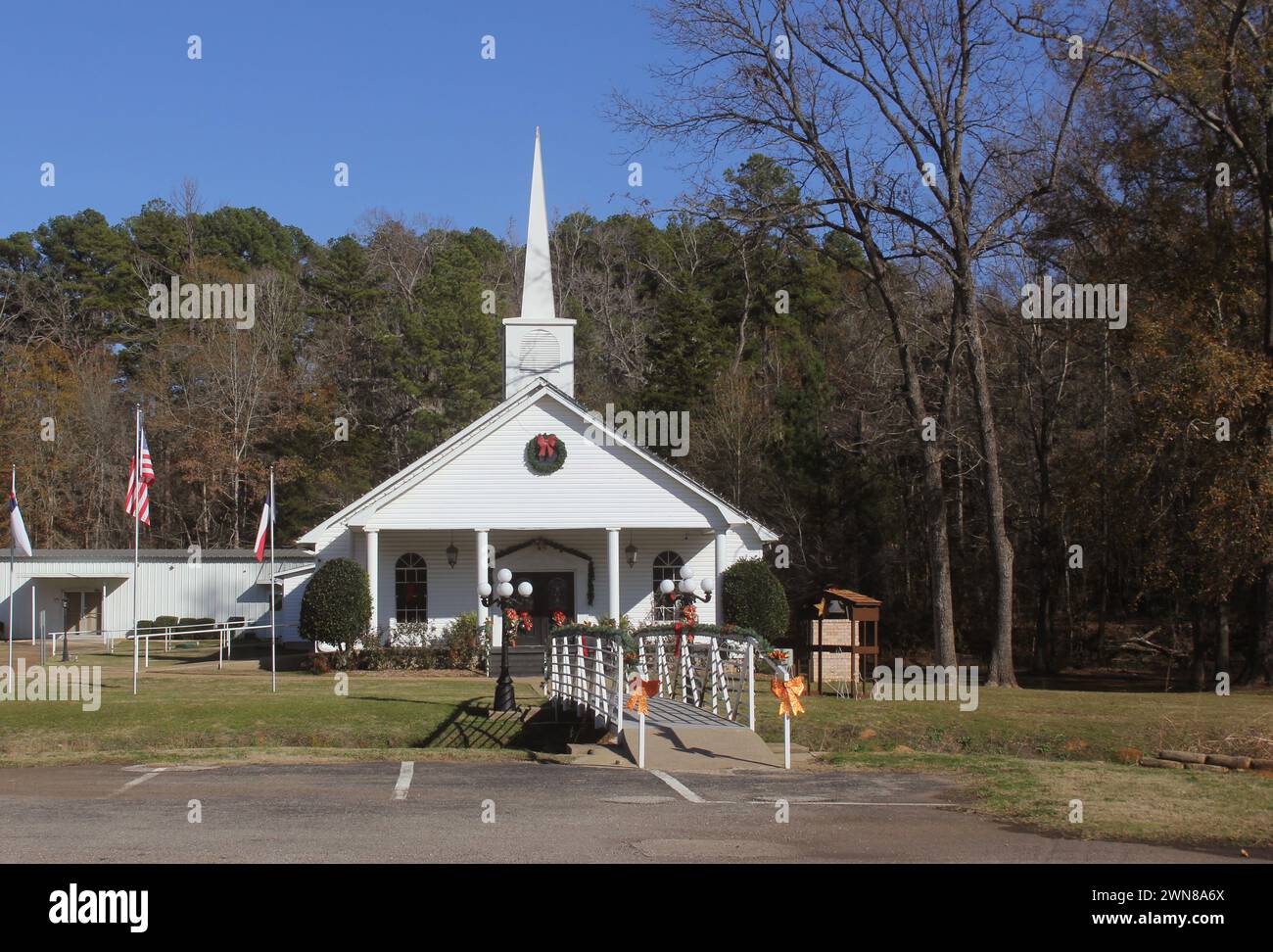 Une église rurale pittoresque de l'est du Texas ornée de décorations de Noël festives sous un ciel bleu vif Banque D'Images