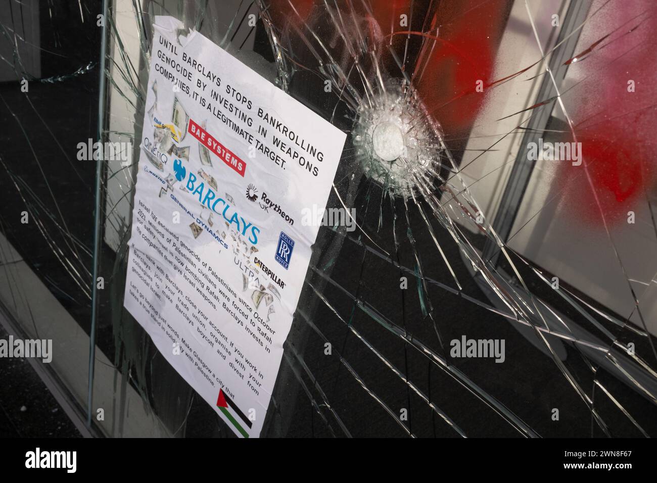 Glasgow, Royaume-Uni, 1er mars 2024. Fenêtres brisées et graffitis lisant « Barcleys Funds génocide » et « Free Palestine » sur la Barclays Bank dans le quartier Shawlands de Glasgow, en Écosse, le 1er mars 2024. Photo de Jeremy Sutton-Hibbert/Alamy Live News. Banque D'Images