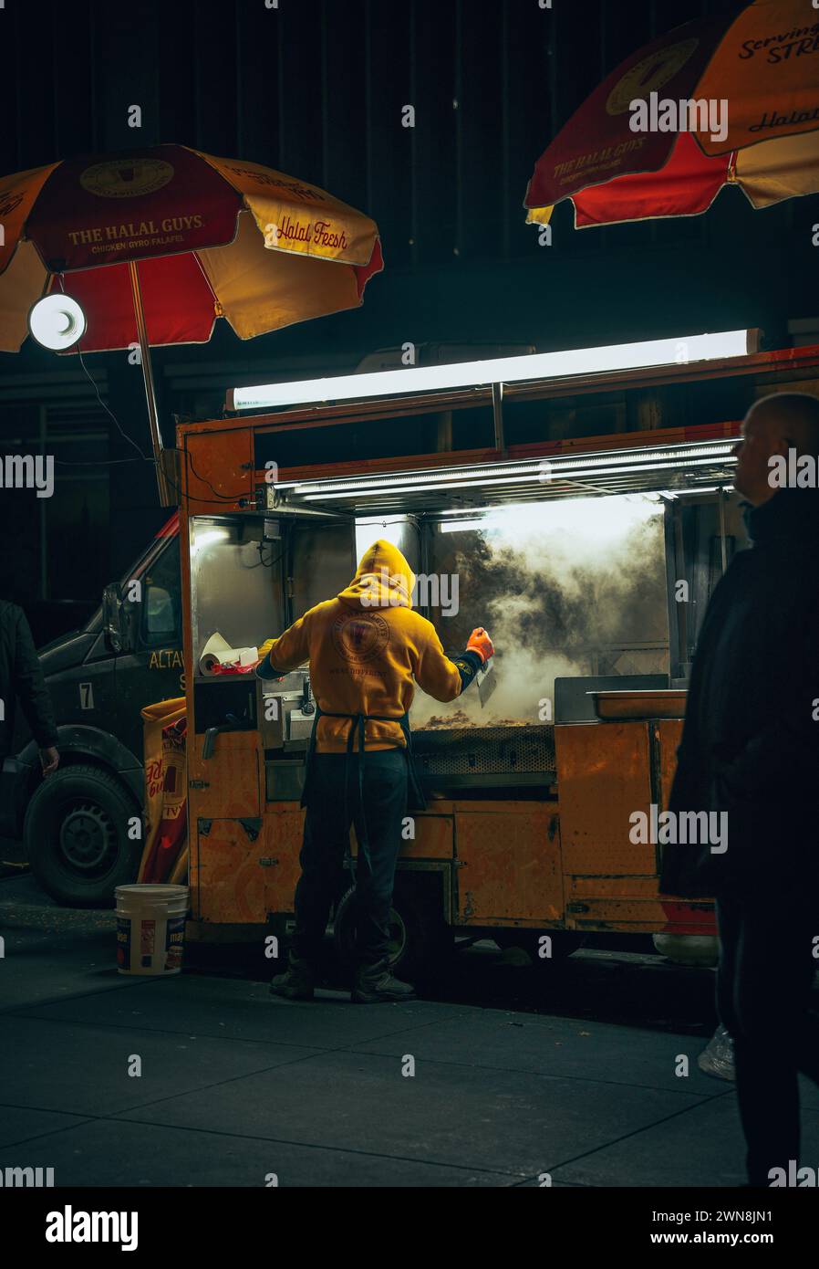 Une personne grillant des kebabs dans une rue de New York la nuit, USA Banque D'Images