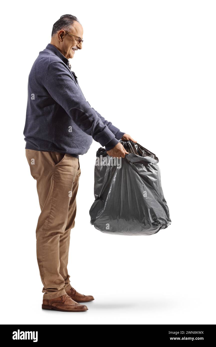 Homme mature tenant un sac poubelle en plastique noir isolé sur fond blanc Banque D'Images