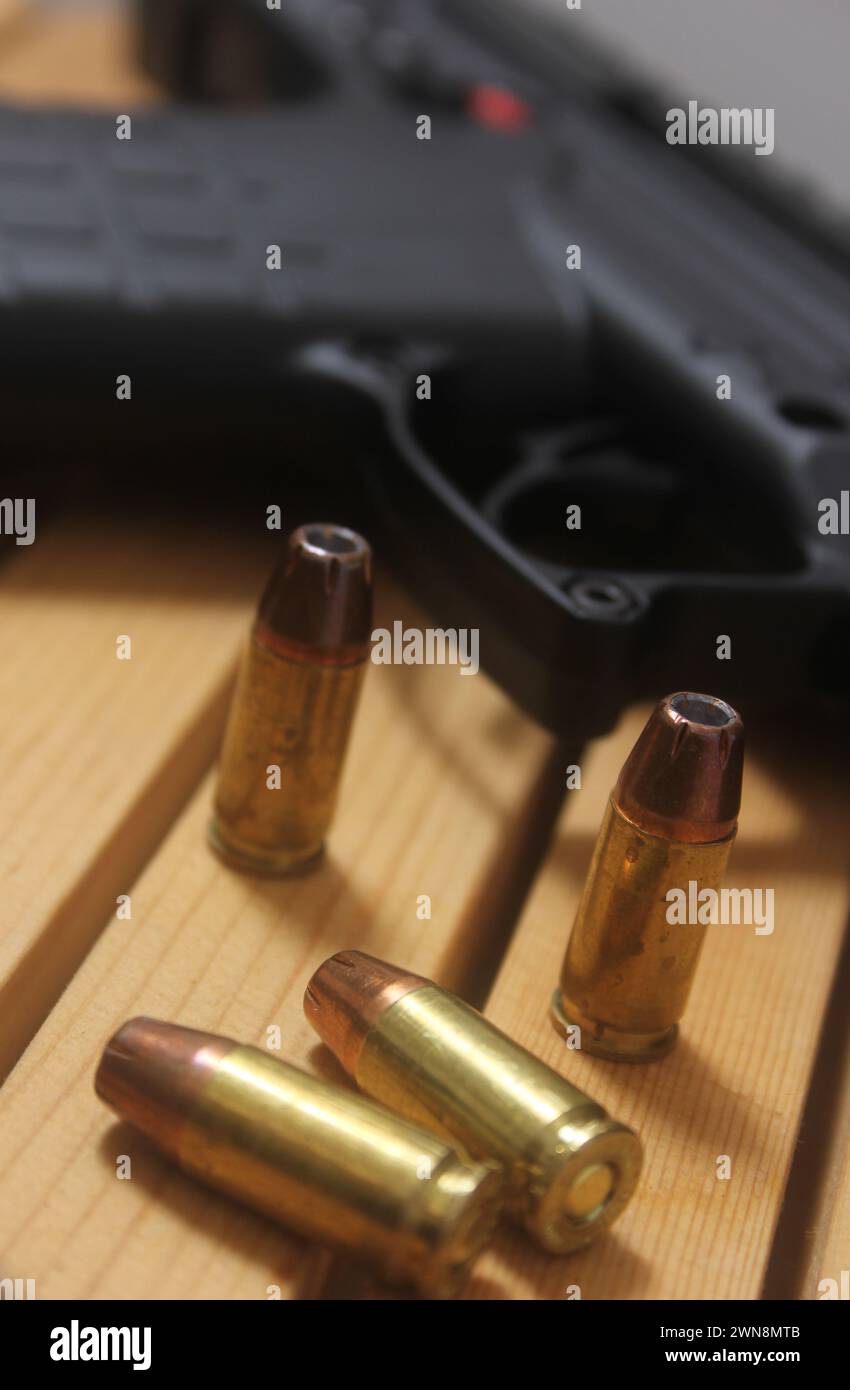 Un pistolet avec des balles sur une table en bois Banque D'Images