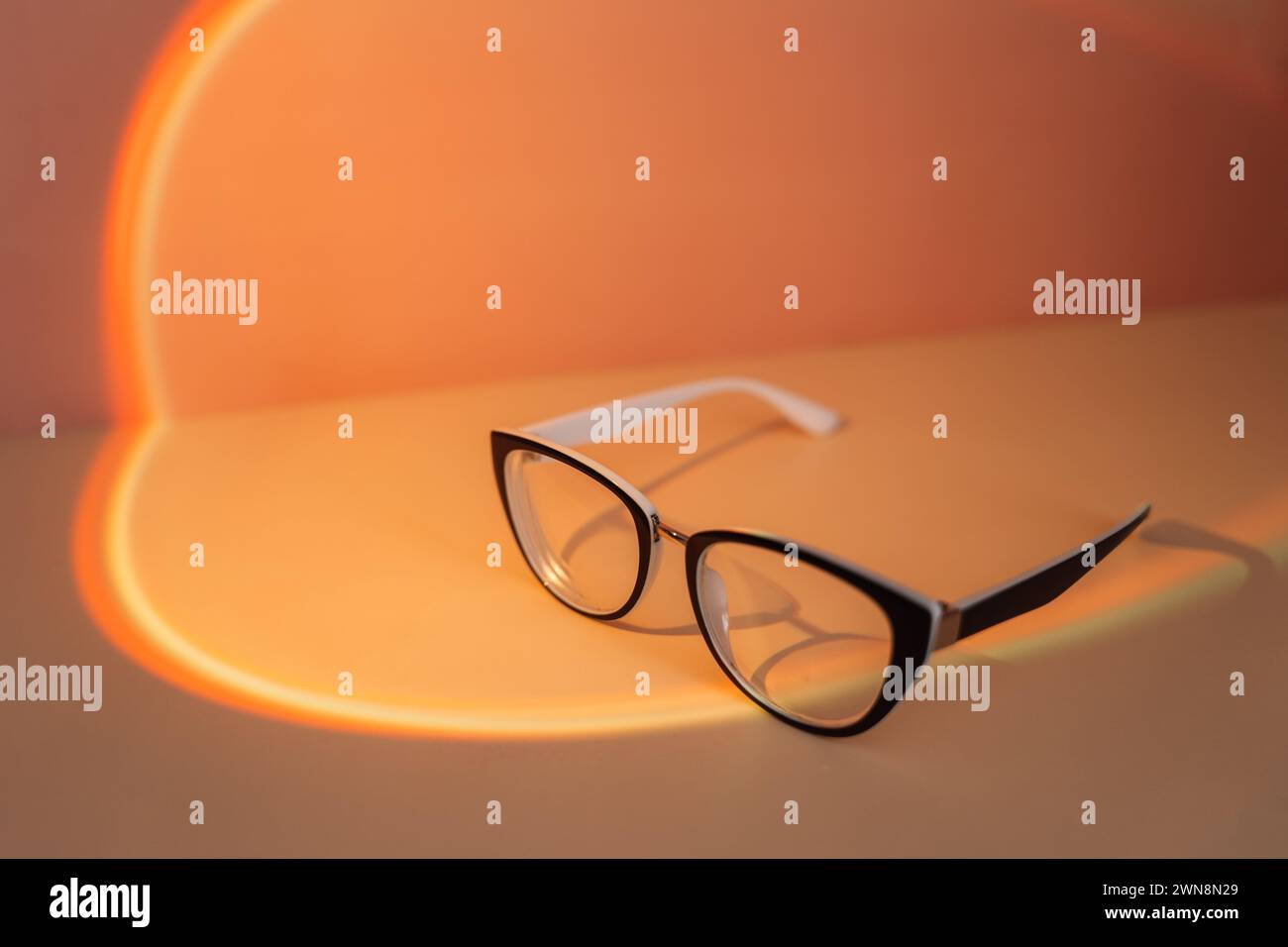 Lunettes de vision avec montures noires sous lumière orange Banque D'Images