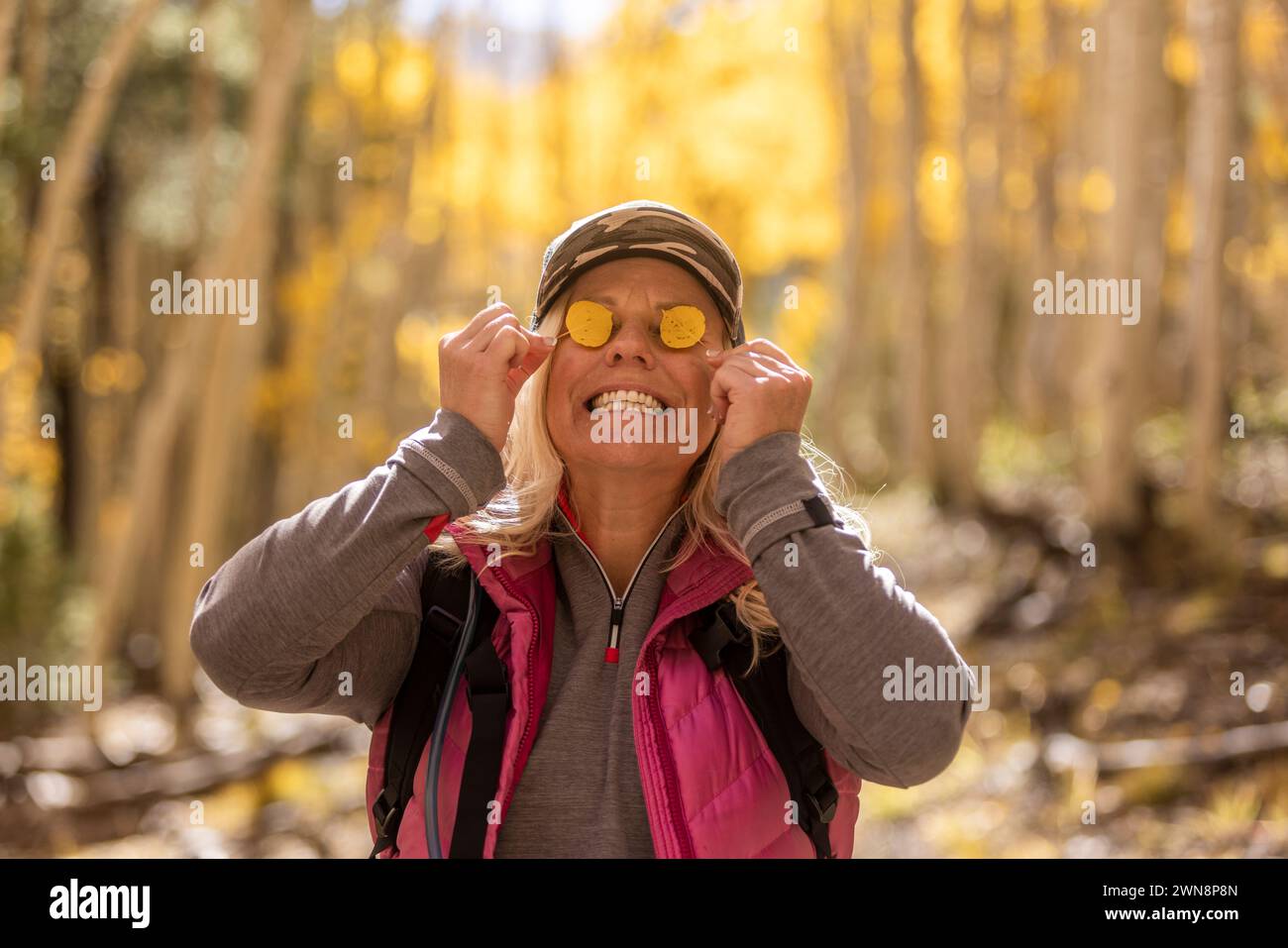 Une femme avec des feuilles jaunes ornant ses yeux Banque D'Images
